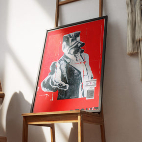 Resist – Urban Street-Art Poster, gerahmt an einer Wand über einem Stuhl